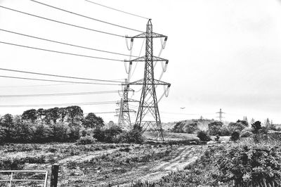 Electricity pylon on field against clear sky