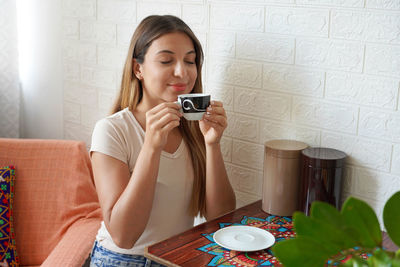 Coffee ads. beautiful girl appreciates the smell of coffee at home. 