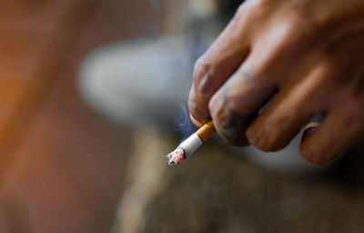 Close-up of hand holding cigarette