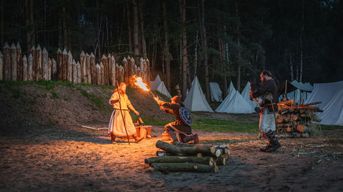 People relaxing on log in forest