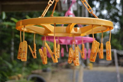 Close-up of clothes pegs hanging from plastic clothesline