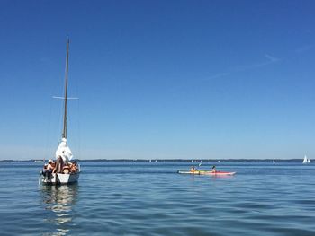 Sailboat sailing on sea against clear sky