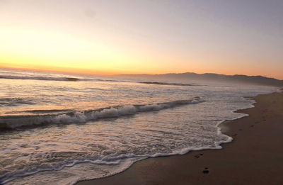 Scenic view of beach against sky during sunset