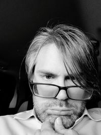 Low angle portrait of mid adult man wearing eyeglasses in darkroom
