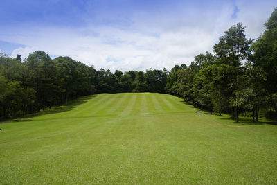 Scenic view of golf course against sky