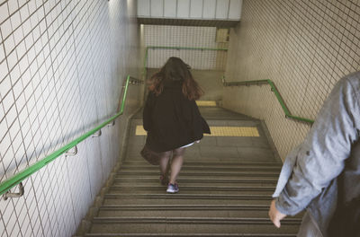 Rear view of woman walking on staircase