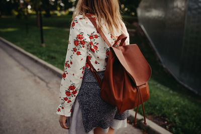 Rear view of woman walking with umbrella