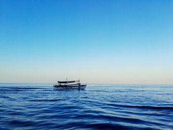 Sailboat in sea against clear sky