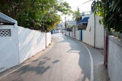 Empty road amidst buildings in city