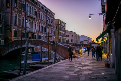 People walking in city against sky