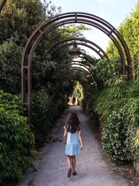 Rear view of woman walking on footpath