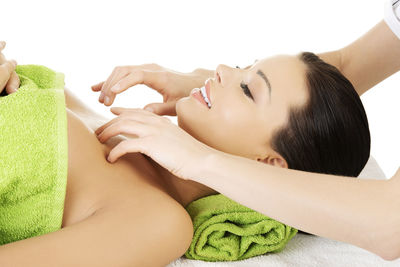 Cropped hands of woman giving massage to customer against white background