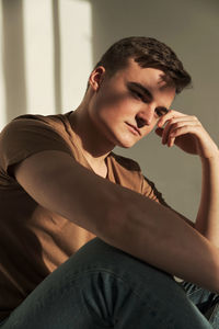 Handsome young man in t-shirt and jeans alone