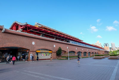 People on building against blue sky