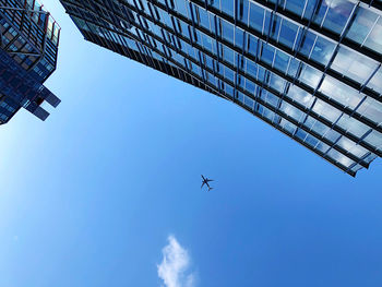 Sky and plane between buildings