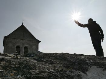 Low angle view of people standing against sky