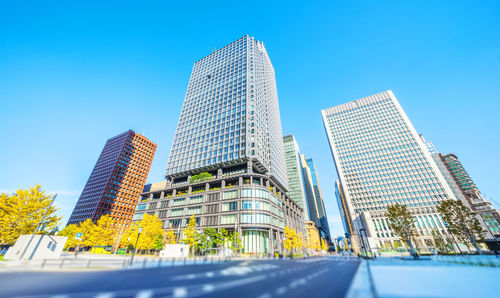 Low angle view of modern buildings against blue sky