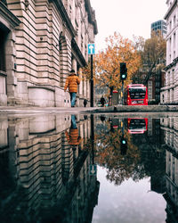 Reflection of buildings in puddle on street