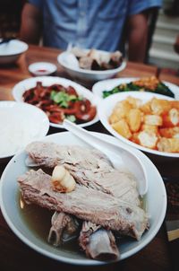 Midsection of man sitting by food served on table