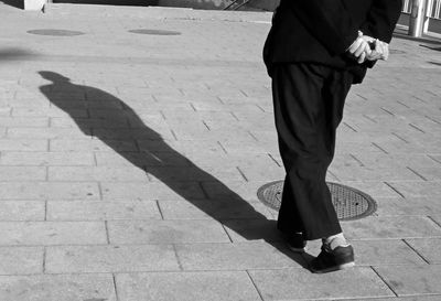 Low section of man standing on footpath