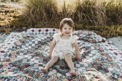 Close up portrait of toddler girl smiling confidently sitting
