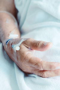 Cropped image of woman wearing iv drip in hospital