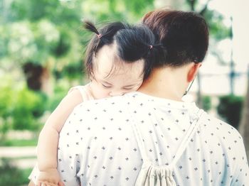 Rear view of mother and daughter outdoors