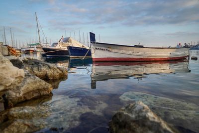 Sailboats moored on sea against sky