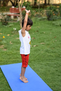 Asian smart kid doing yoga pose in the society park outdoor, children's yoga pose. the little boy