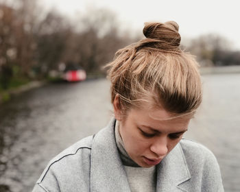 Close-up of woman looking down against lake