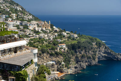 Buildings by sea against sky