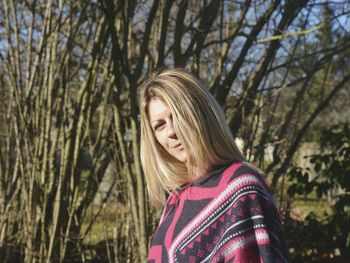 Portrait of mature woman standing against trees