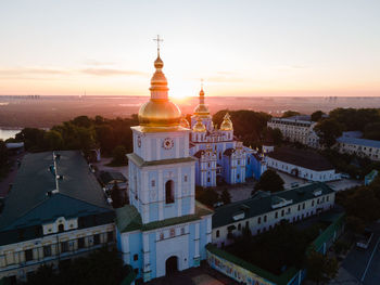 Buildings in city against sky during sunset