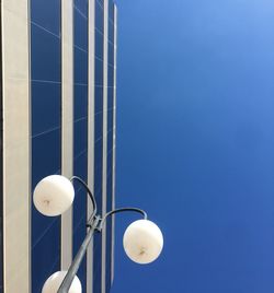 Low angle view of street light against blue sky