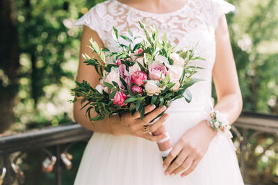 Midsection of woman holding flower bouquet