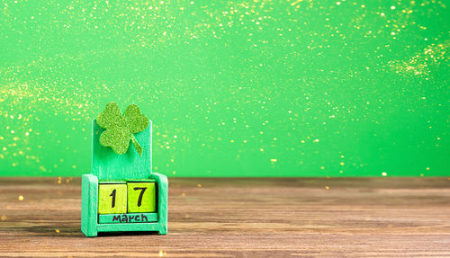 Close-up of toy sign on table against wall