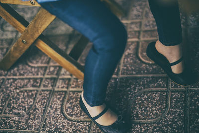 Low section of woman sitting on footpath