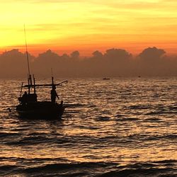 Silhouette sailboats in sea against sky during sunset