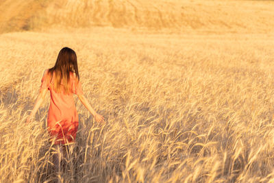 Rear view of woman standing on field