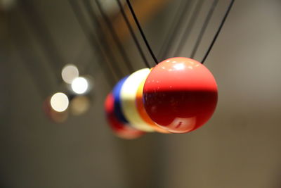 Close-up of pendulums hanging against wall