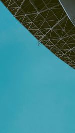 Low angle view of crane against clear blue sky