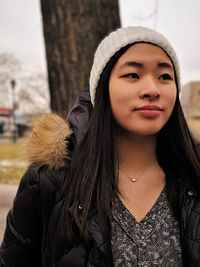 Young woman wearing knit hat while standing outdoors