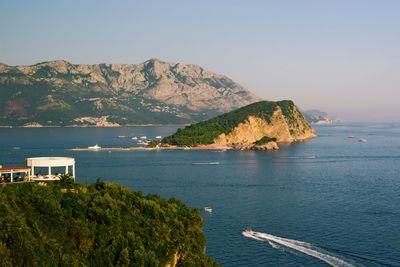 Scenic view of sea and mountains against sky