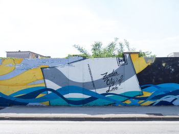 Graffiti on wall in front of colorful sky