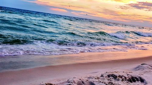 Scenic view of beach against sky during sunset