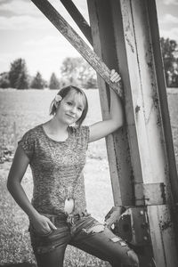 Portrait of woman standing by metallic column