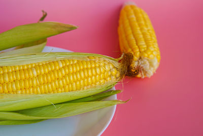 Close-up of banana on table against colored background