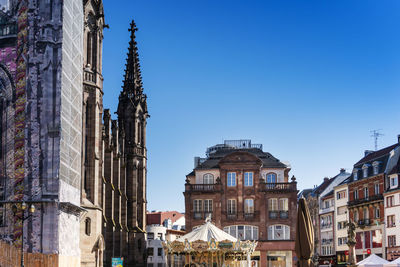 Buildings in city against clear blue sky