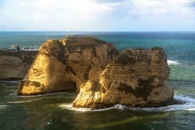 Rock formation in sea against sky