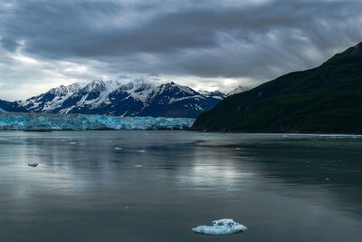 Scenic view of snow covered mountains against cloudy sky